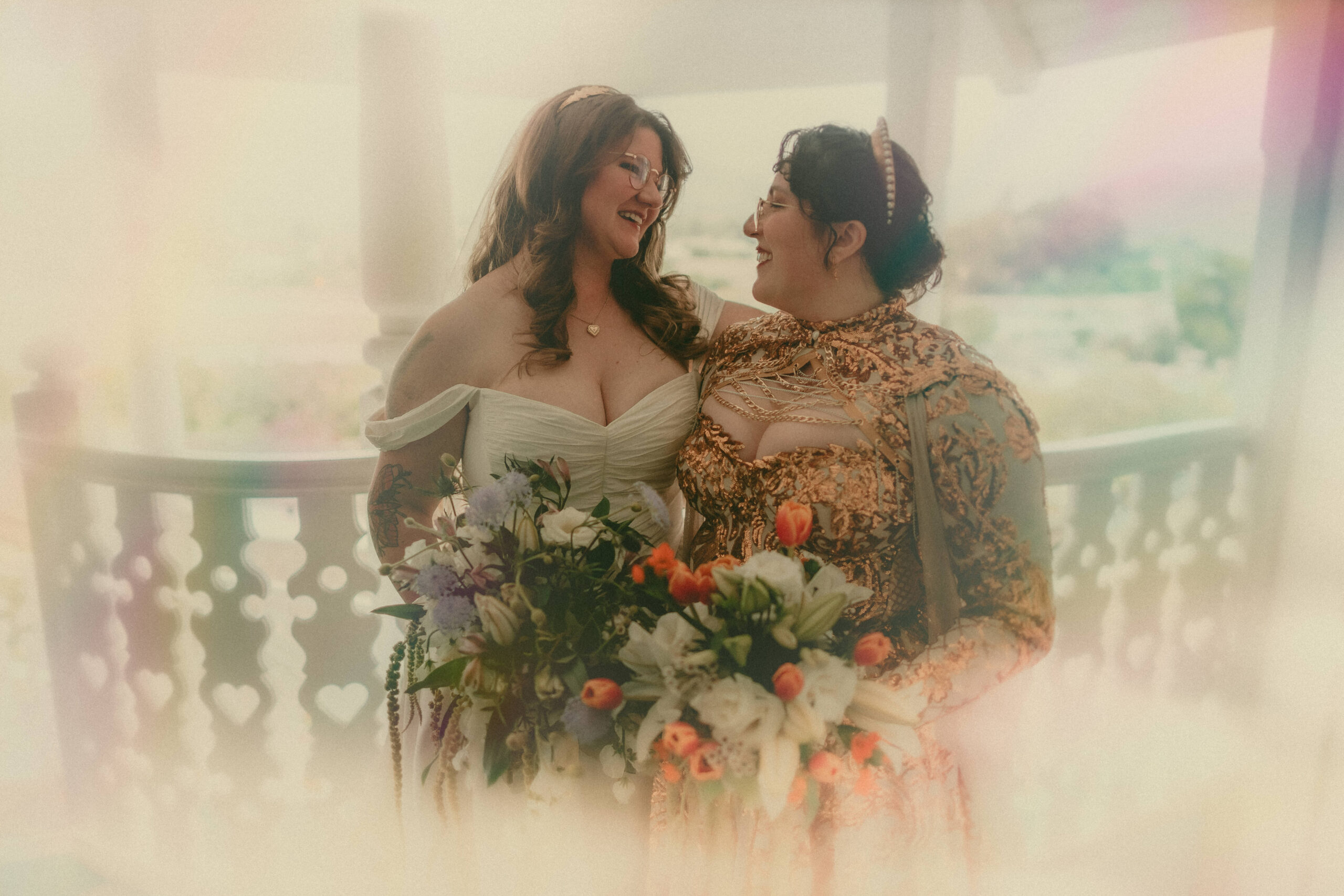Close emotional portrait of two brides illuminated by a rainbow prism