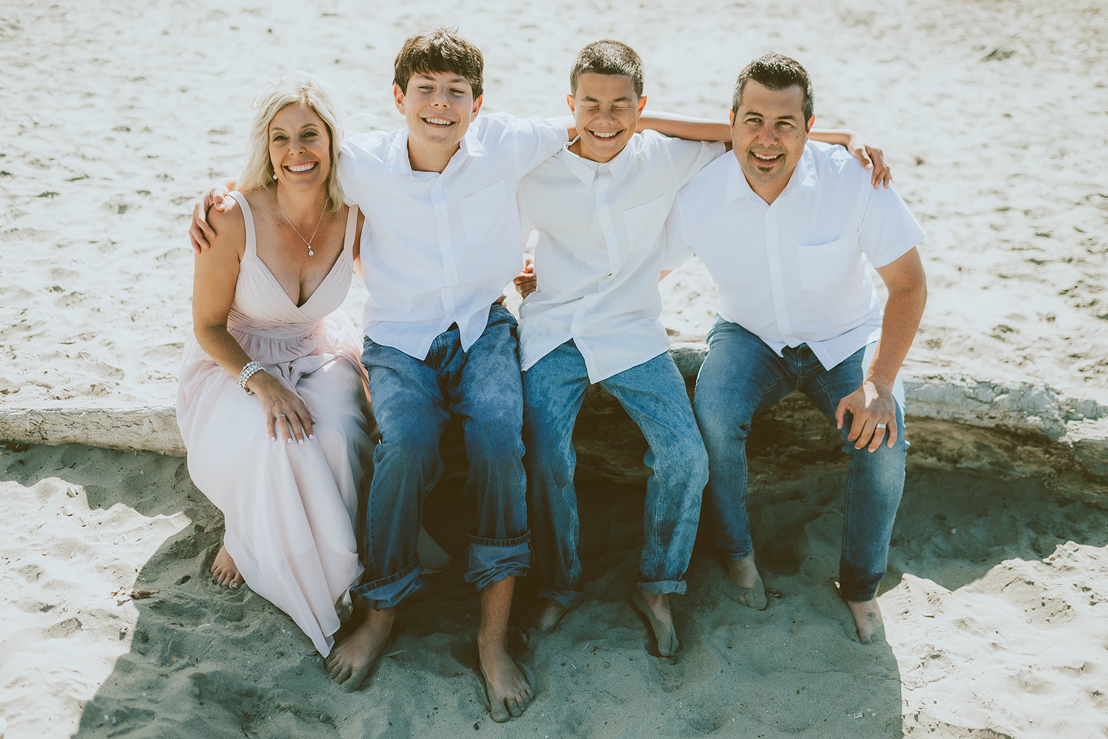 Family seated closely together on a Central Coast beach