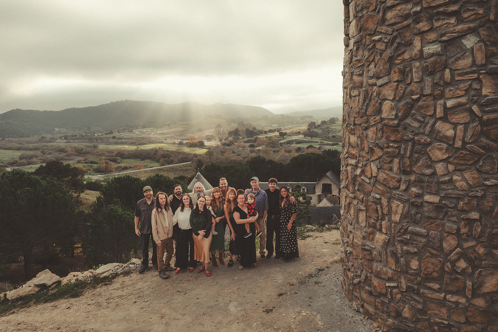 Large family gathered beside a stone tower