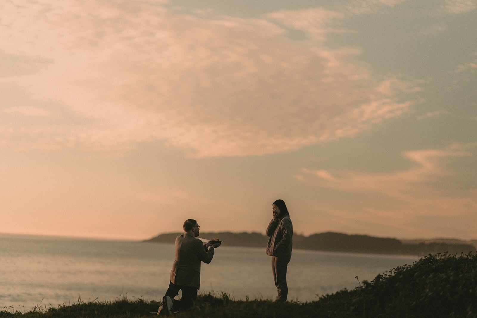 Wide silhouette of a kneeling proposal at sunset