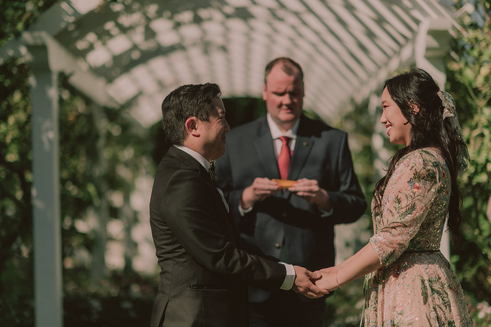 Wedding ceremony beneath a floral garden arch