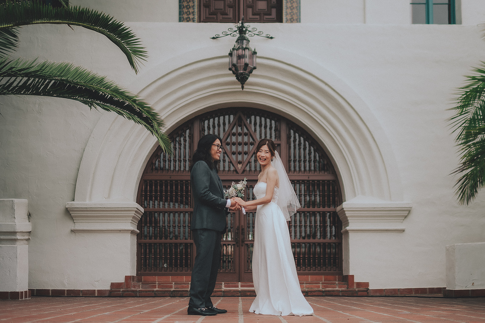 Newlyweds beneath an arched Santa Barbara Courthouse entrance