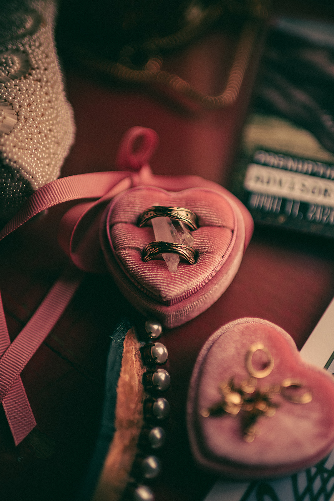 Wedding rings tucked into a pink heart-shaped case