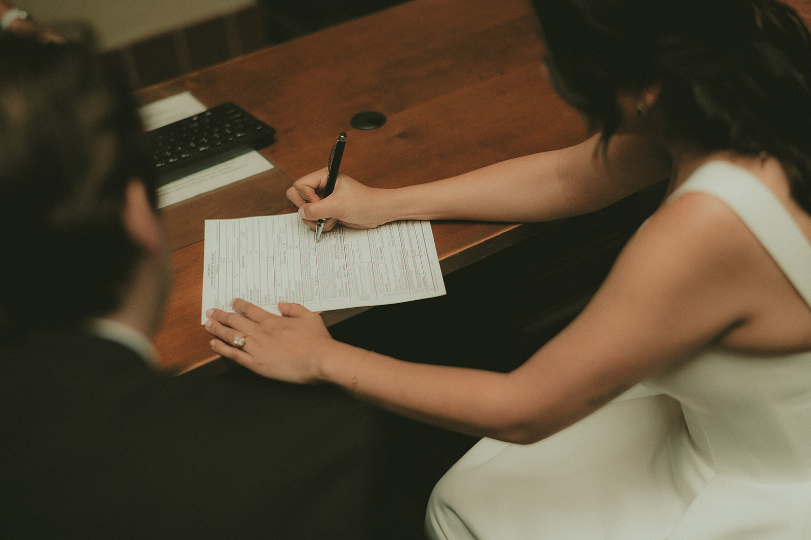Couple calmly signing their marriage paperwork at the courthouse
