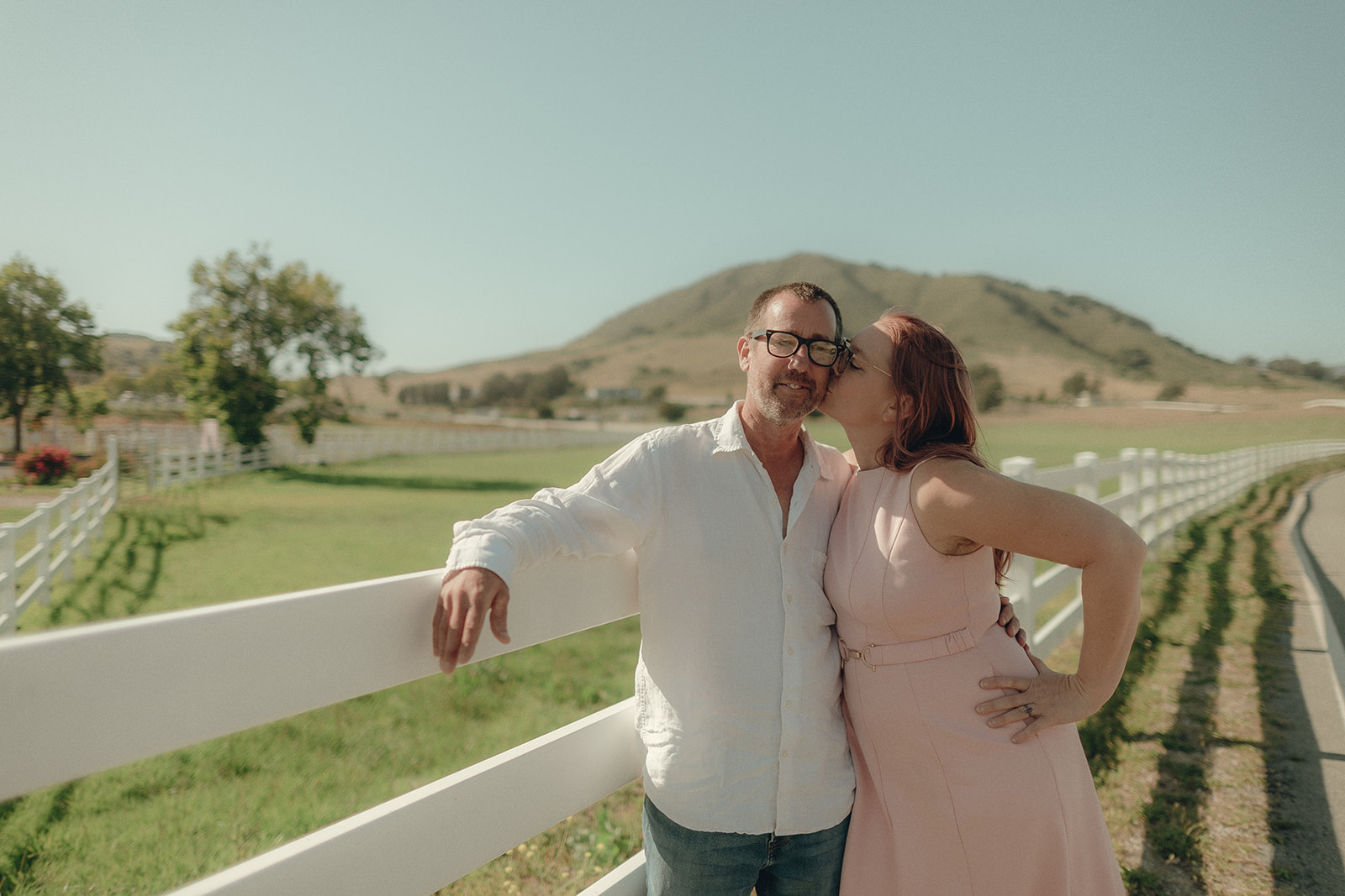 Playful couple twirling together in a vineyard