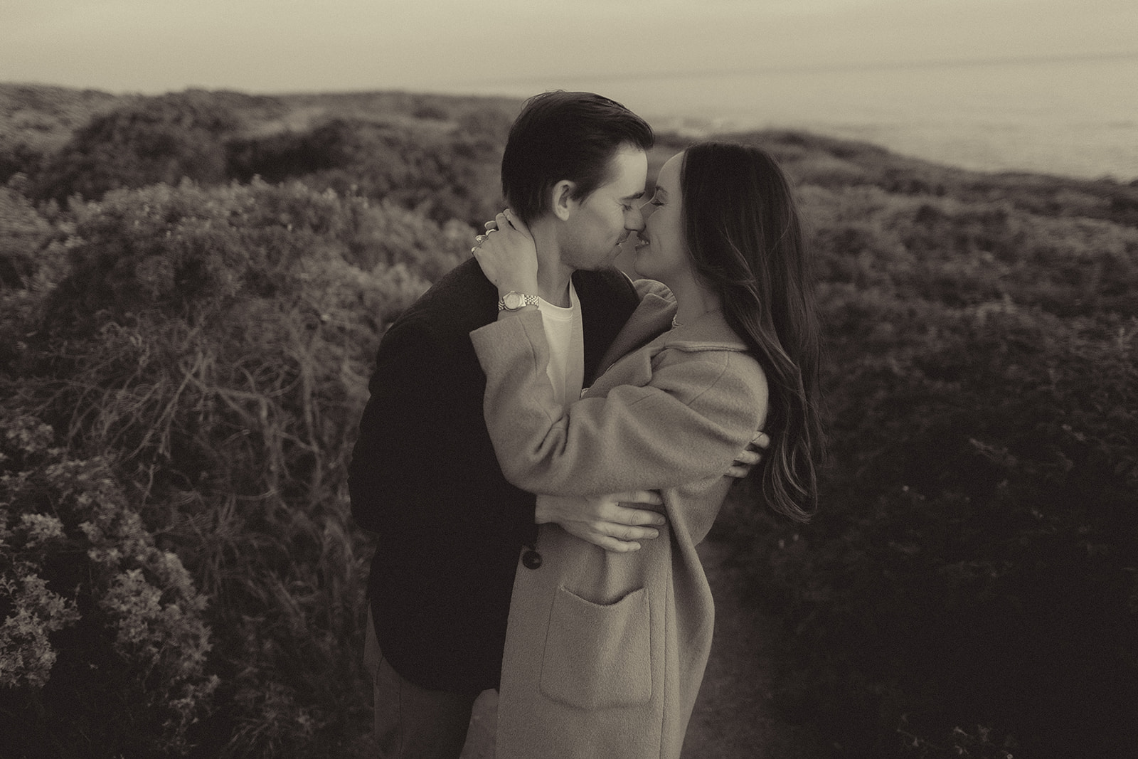 Black-and-white emotional embrace after a surprise proposal