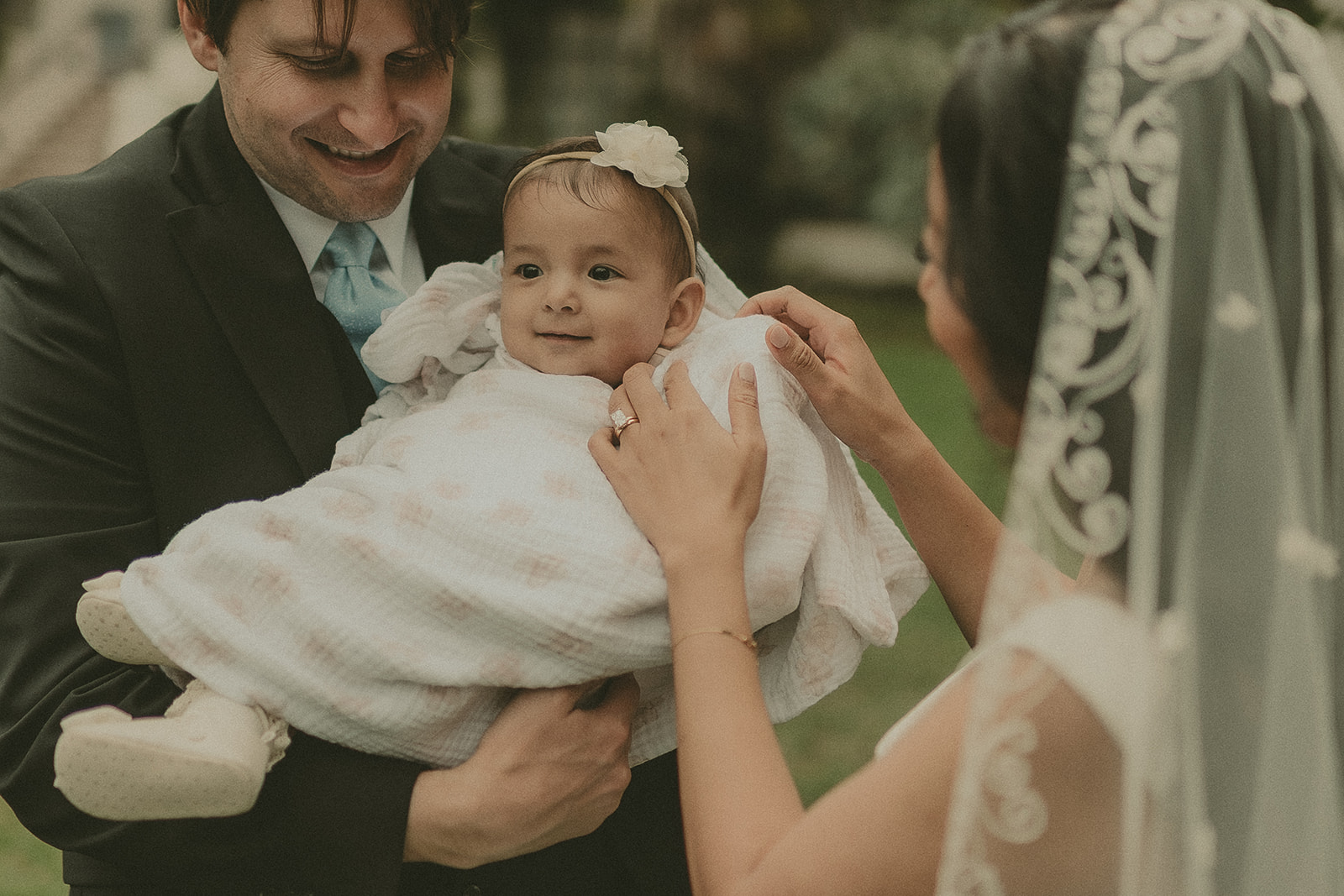 Newlyweds sharing a close family moment with their baby