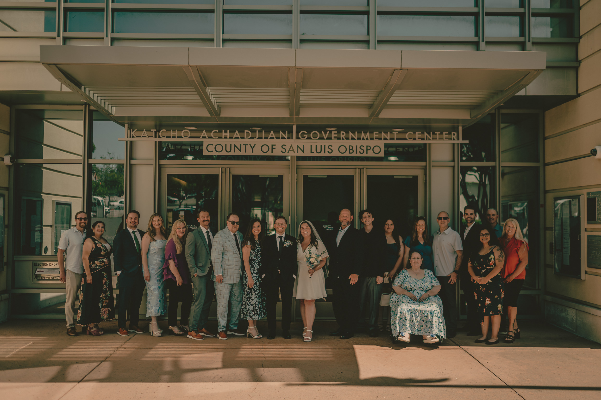 Tiffani and Braden stand with their full wedding group outside the courthouse.