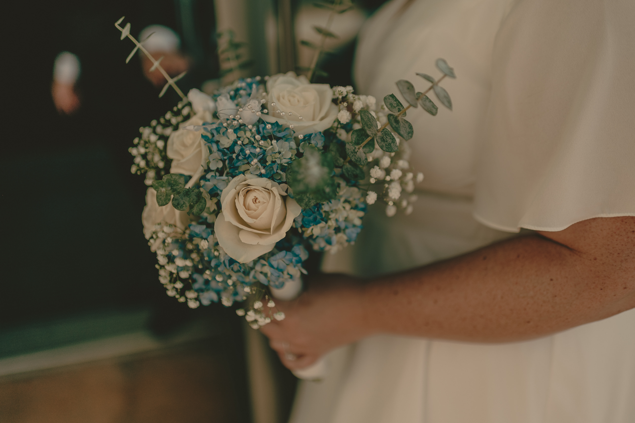 A close photograph of Tiffani's white and blue wedding bouquet.