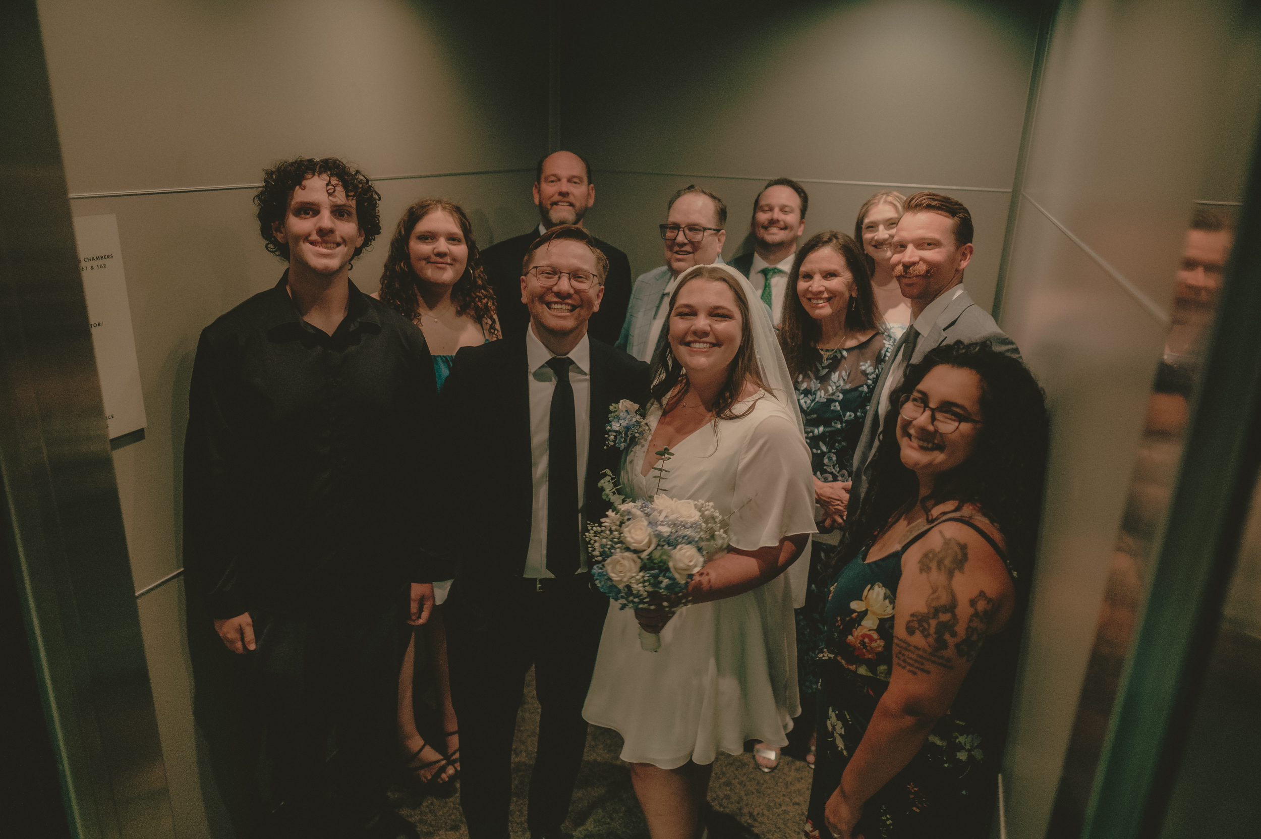 Tiffani, Braden and their guests crowd together inside the courthouse elevator.