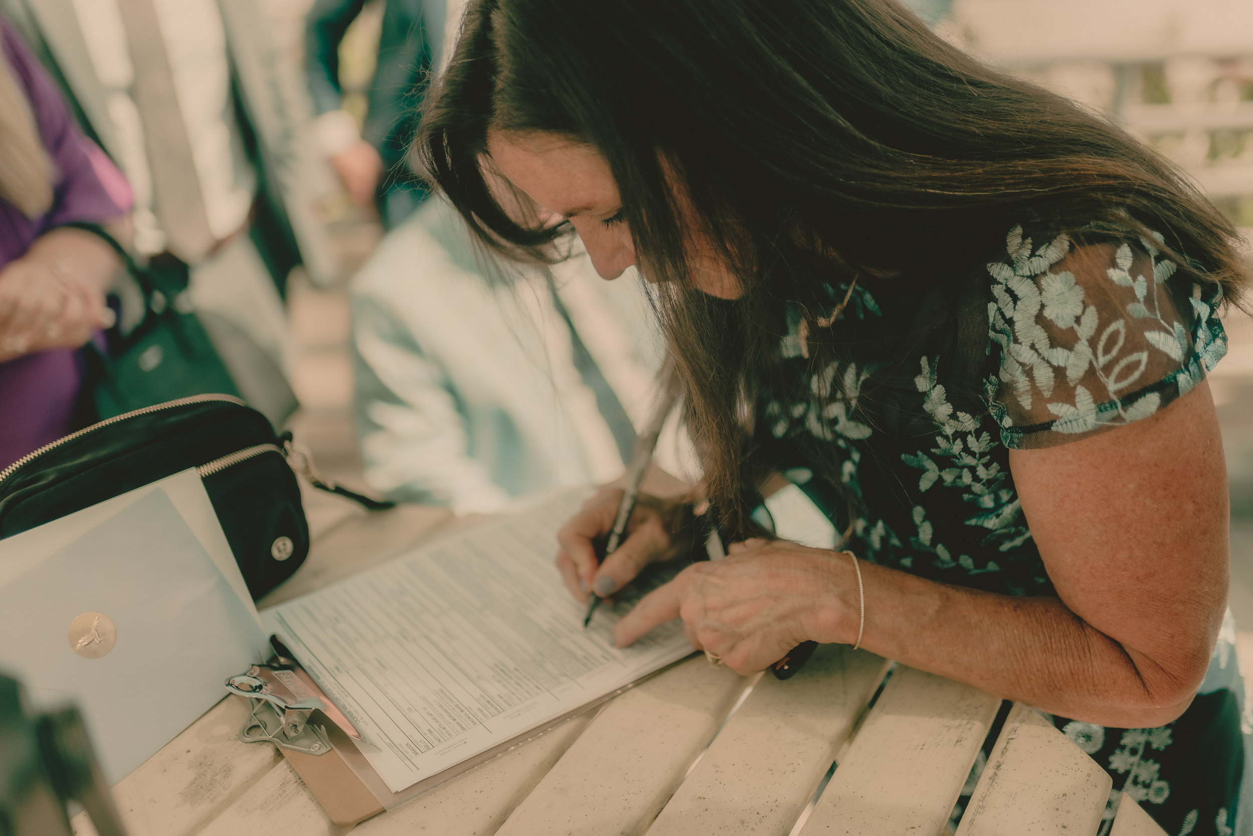 Tiffani and Braden sign their marriage license during the rooftop ceremony.