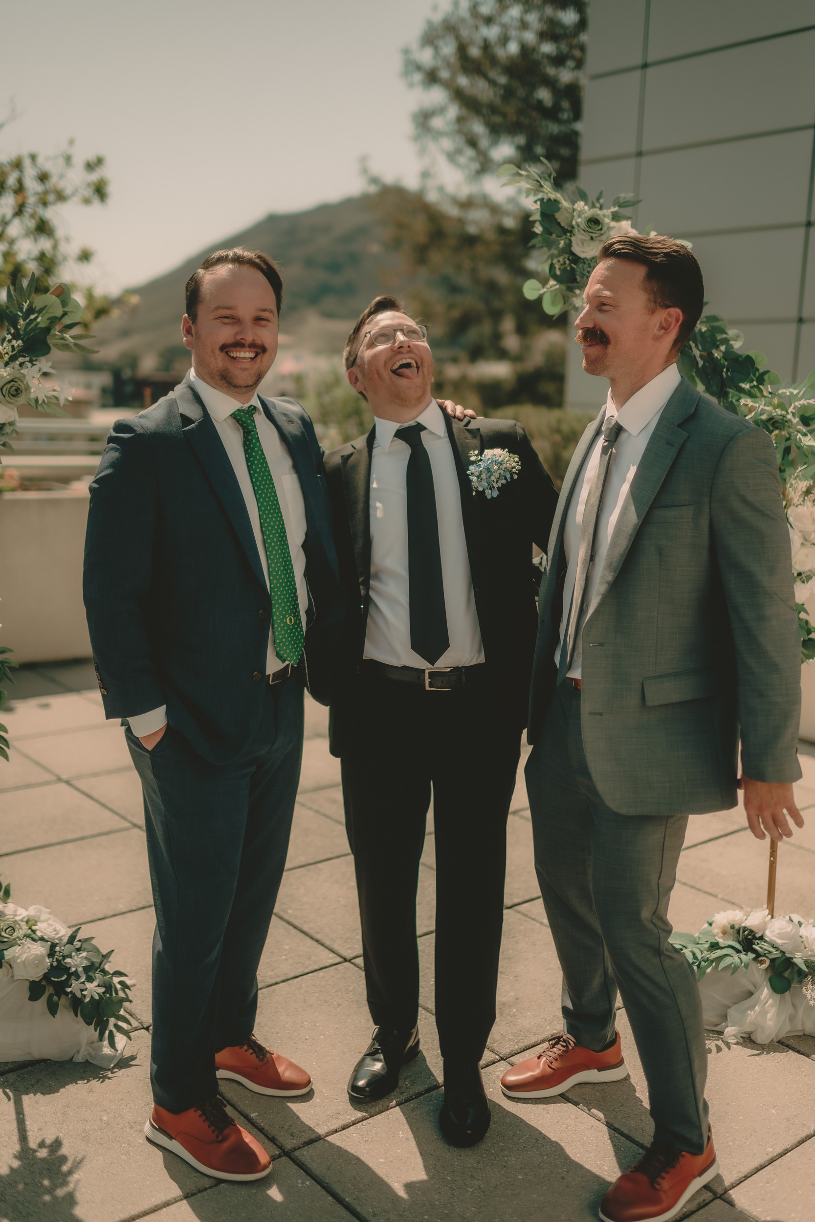 Braden laughs with two wedding guests on the courthouse rooftop.