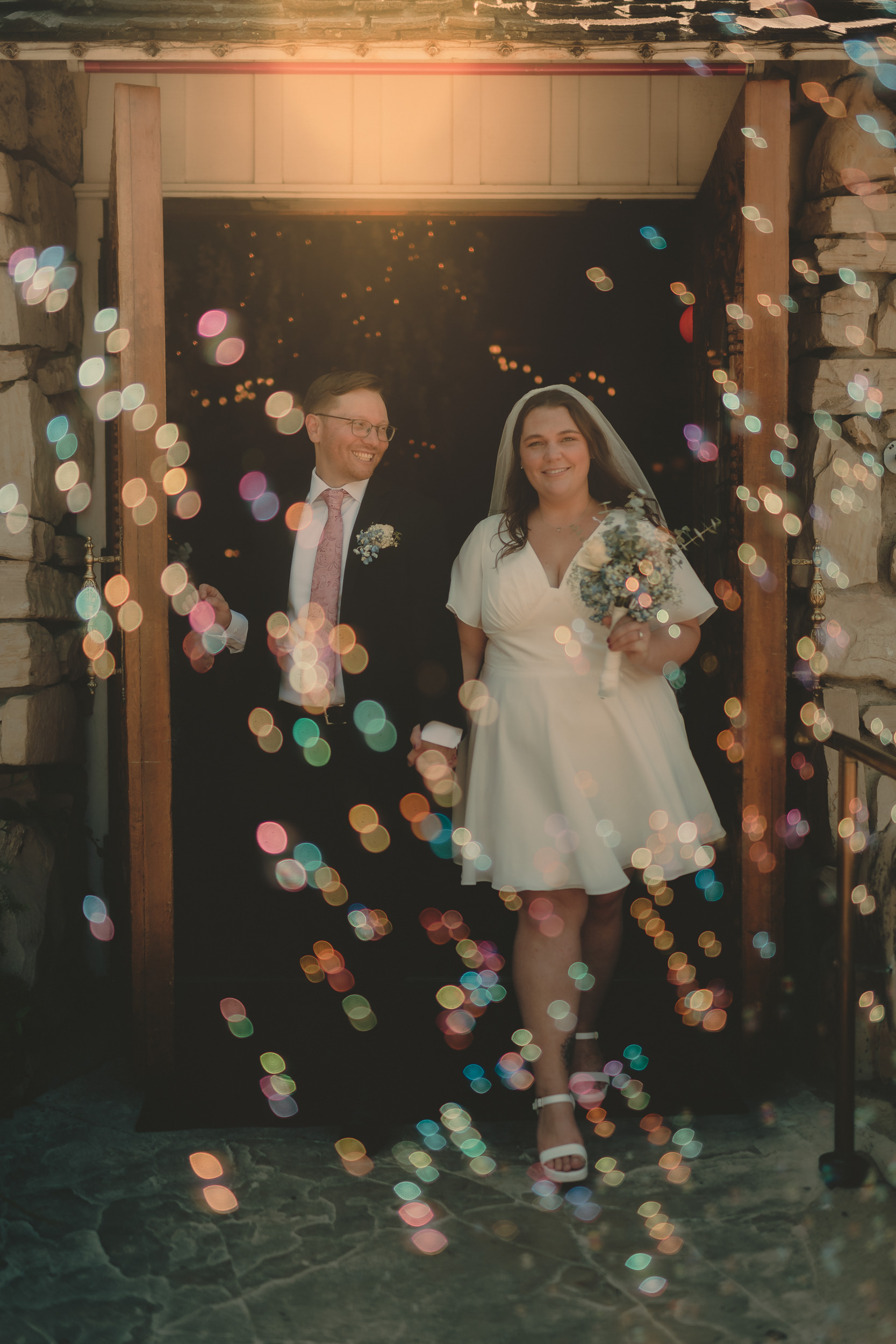 Tiffani and Braden laugh in a doorway surrounded by glowing bubbles.