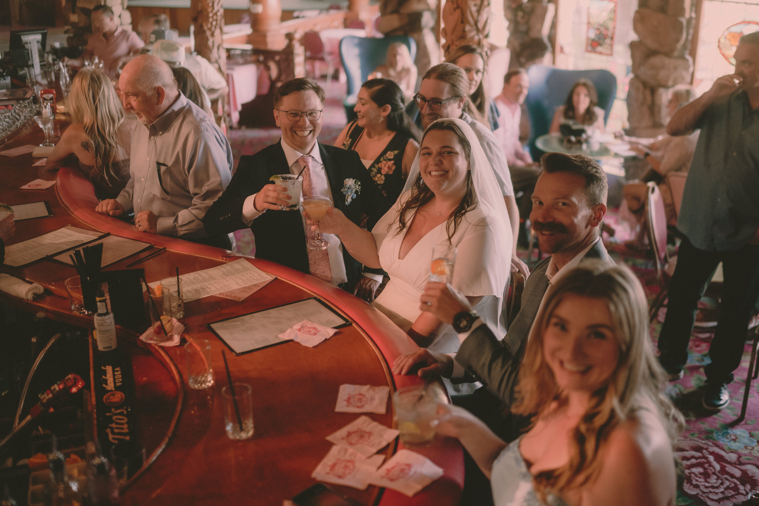 Tiffani and Braden raise drinks with guests inside Madonna Inn.