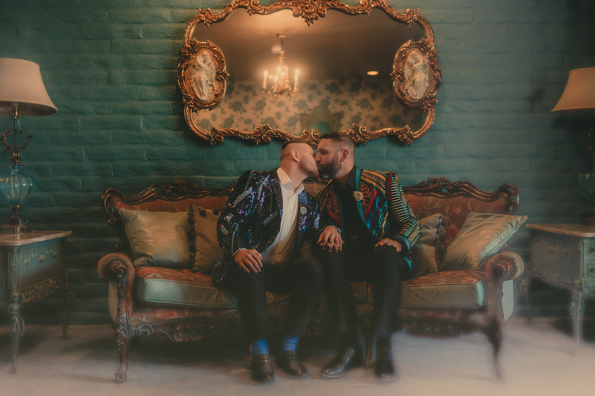 Sean and Stephan kiss on an ornate sofa in the green-and-gold Madonna Inn lounge.