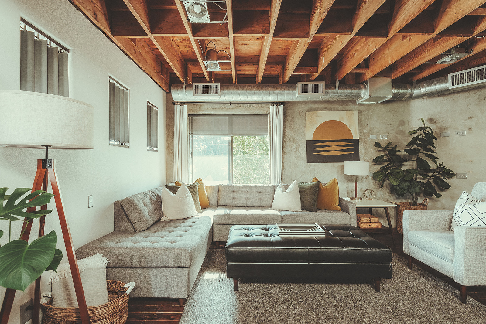 Industrial-style living room with exposed wood beams in a San Luis Obispo Airbnb