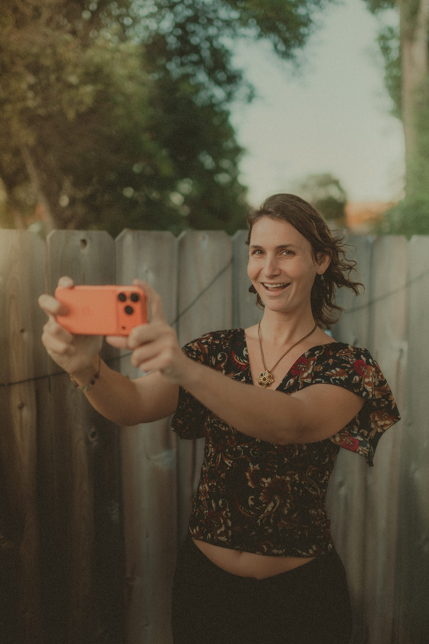 Faith smiling while filming horizontally with an iPhone.