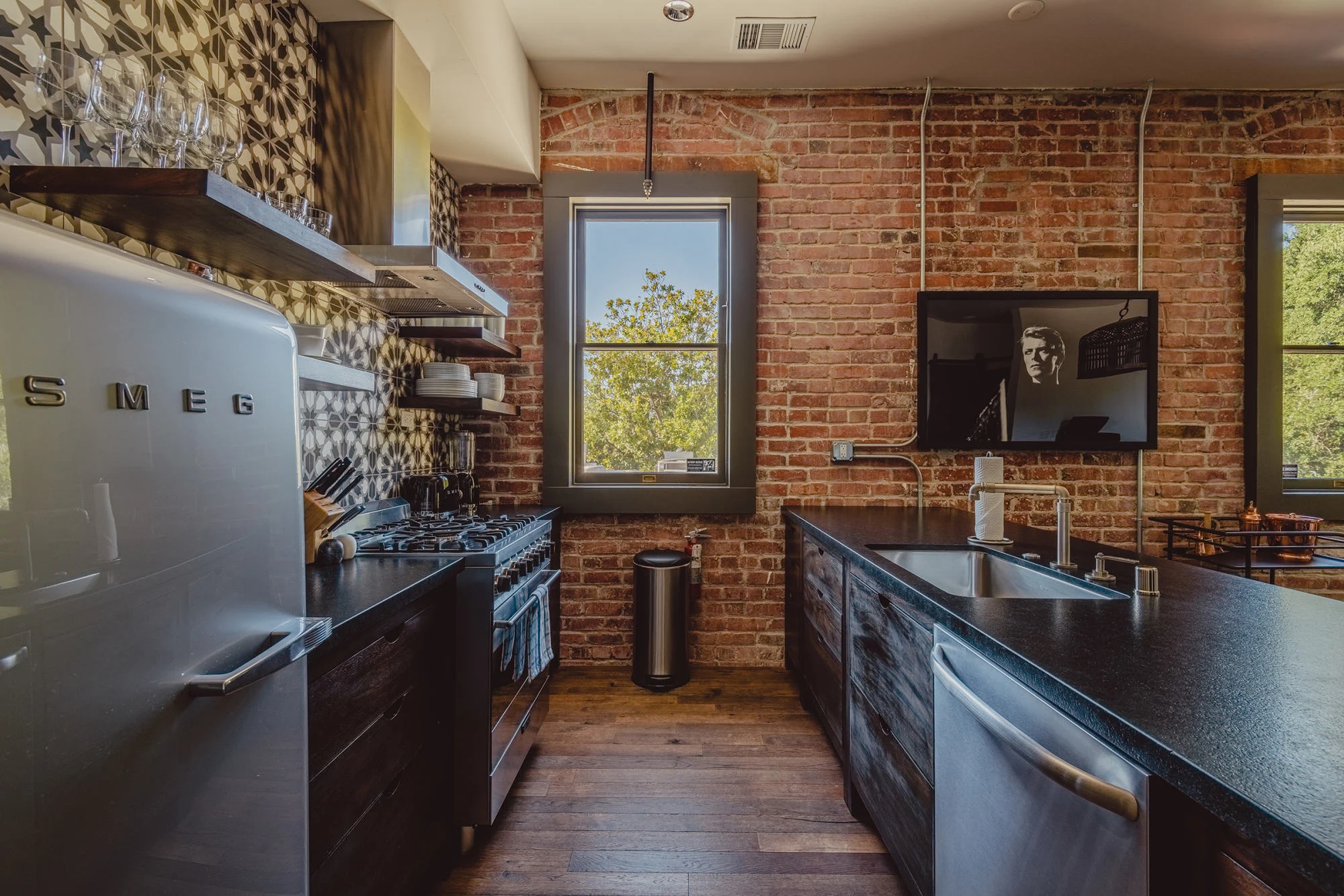 Warm brick, patterned tile, and a vintage-style refrigerator in a SLO Brew Lofts kitchen